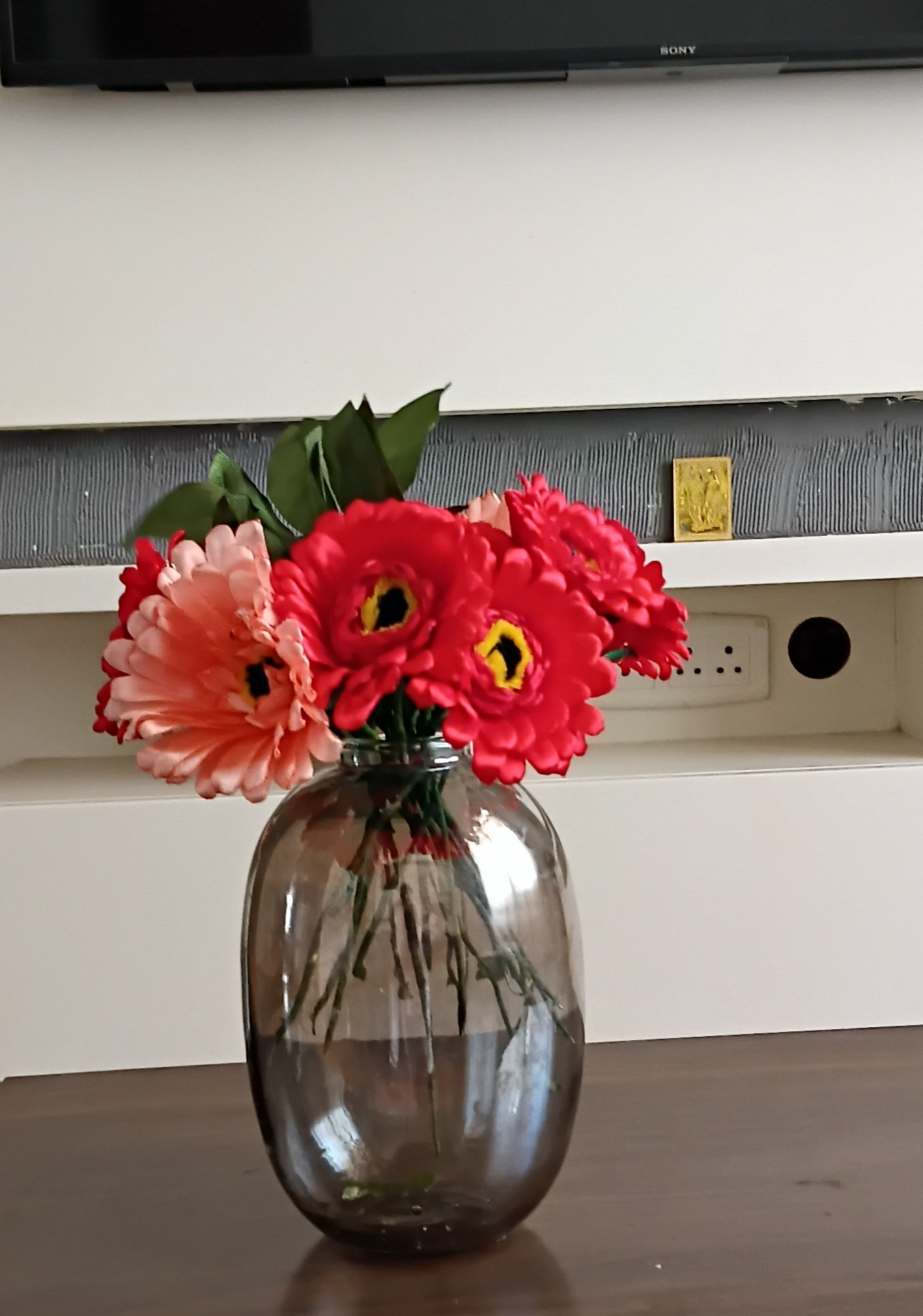 Handcrafted satin flower arrangement in a glass vase."
